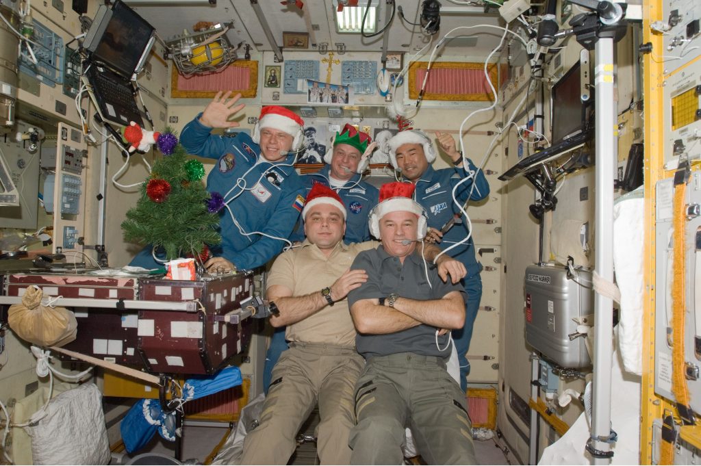 Expedition 22 crew members celebrate the holidays aboard the orbital outpost in Dec. 2009. In the front row are NASA astronaut Jeffrey Williams, commander (right), and Russian cosmonaut Maxim Suraev, flight engineer. In the back row, from left, are Russian cosmonaut Oleg Kotov, NASA astronaut T.J. Creamer, and JAXA astronaut Soichi Noguchi, all flight engineers. All crew members pictured are former astronauts.