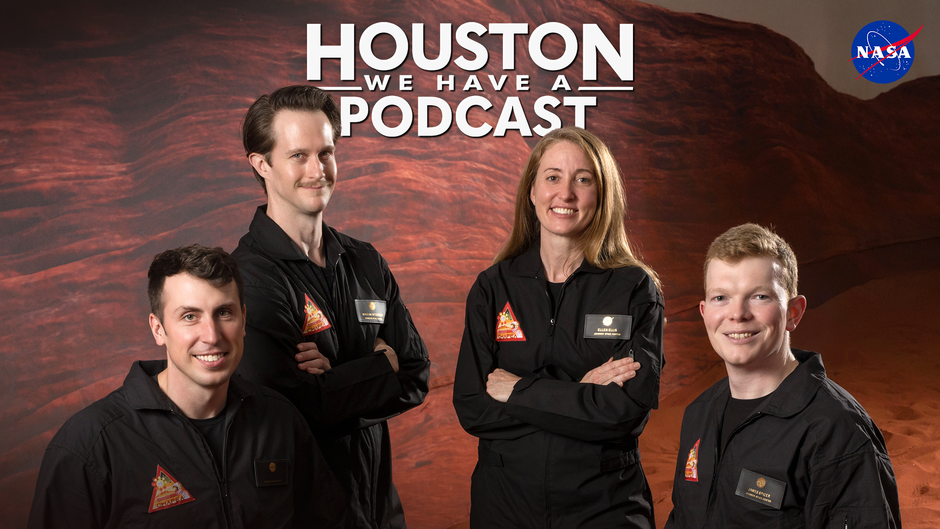 HWHAP Ep. 404. Three men and a woman pose in dark flight suits on a simulated Mars surface.