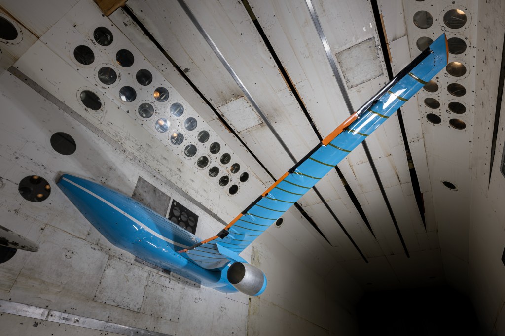 A scale model of possible future commercial jet airplane sits inside a NASA wind tunnel where the aircraft wing was tested.
