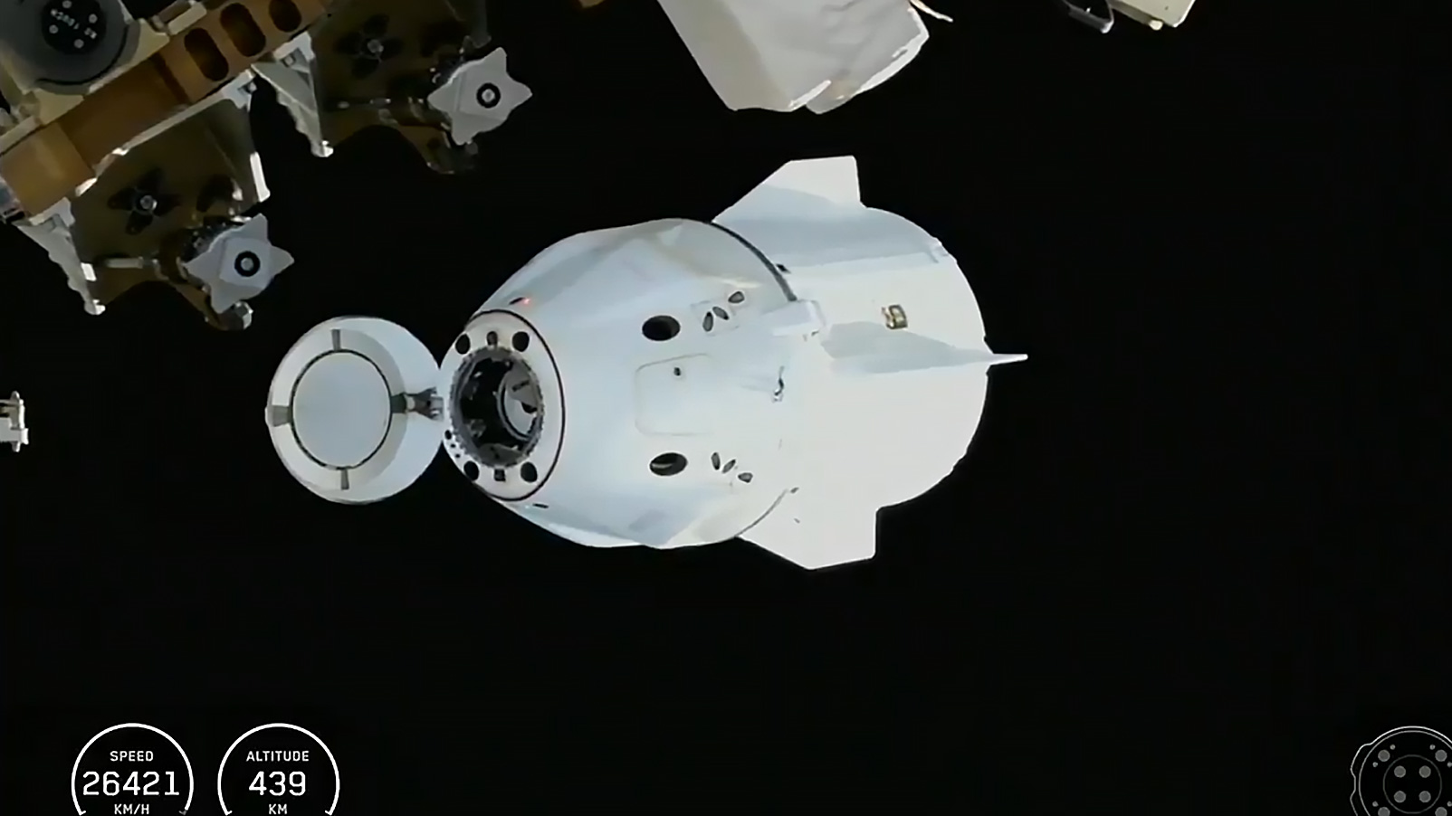 The SpaceX Dragon crew spacecraft, with its nose cone open and carrying four Crew-11 members, departs the International Space Station shortly after undocking from the Harmony module's space-facing port.