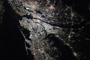 The New York–Newark–Jersey City Metropolitan Area at night. City lights illuminate most of the image.
