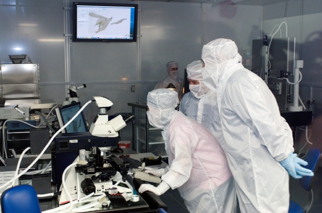 French Scientist Francois Robert (right) helps examine a sample obtained from the Stardust Mission in the Stardust Laboratory in Building 31, Johnson Space Center (JSC).