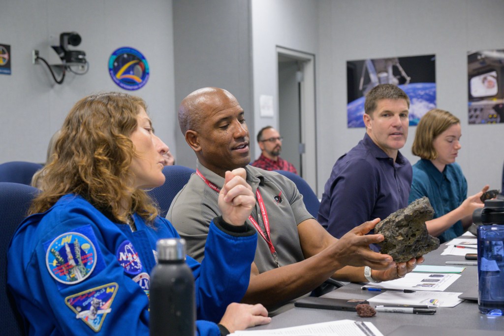 Artemis II crew members, from left, NASA astronauts Christina Koch and Victor Glover, CSA (Canadian Space Agency) astronauts Jeremy Hansen and Jenni Gibbons, study rocks during classroom preparation ahead of their fieldwork training in Iceland. (NASA/Robert Markowitz)