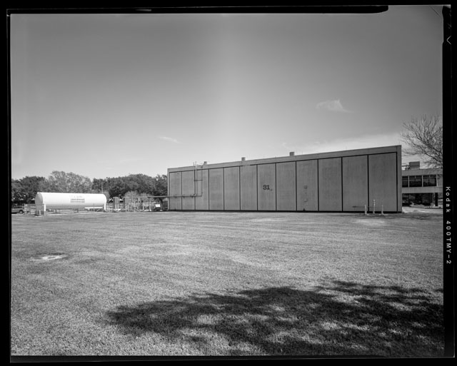 HAER-TX-109-N-02, Oblique Southwest facing corner of High Bay with South facing side of tank farm and portion of West facing side of Admin wing