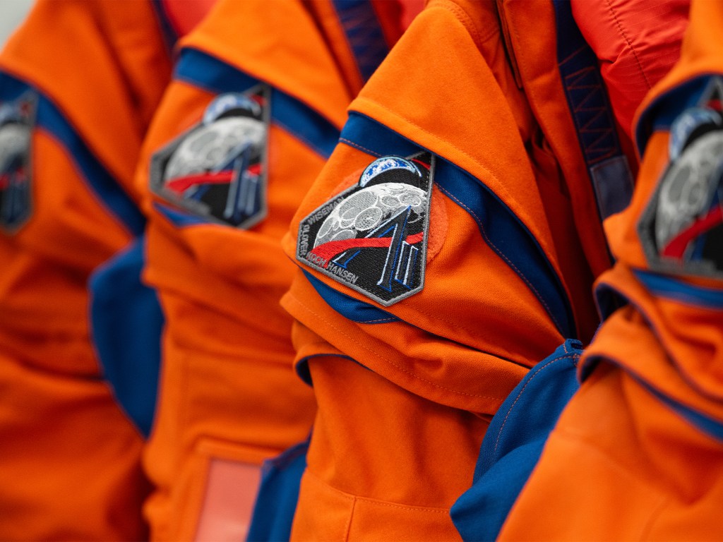 Artemis II patches are seen on the shoulders of a spacesuit used by astronauts.