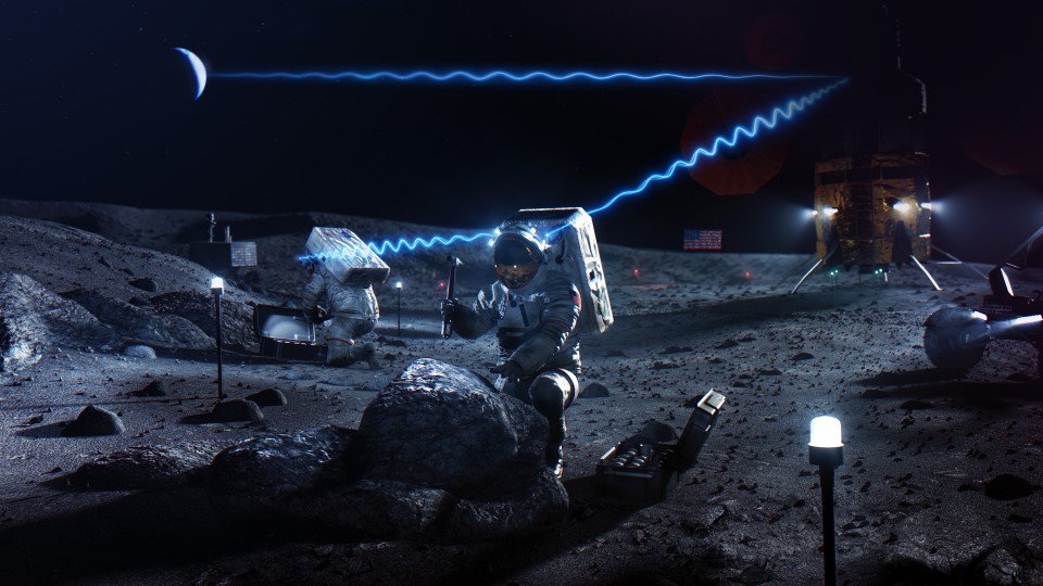 Two astronauts are shown kneeling on the surface of the Moon while they work. A large silver and gold human landing system is shown in the background. Bright blue wavy lines, representing communications signals, are shown connecting the astronauts, the human landing system, and Earth, shown dimly lit over the horizon of the Moon.
