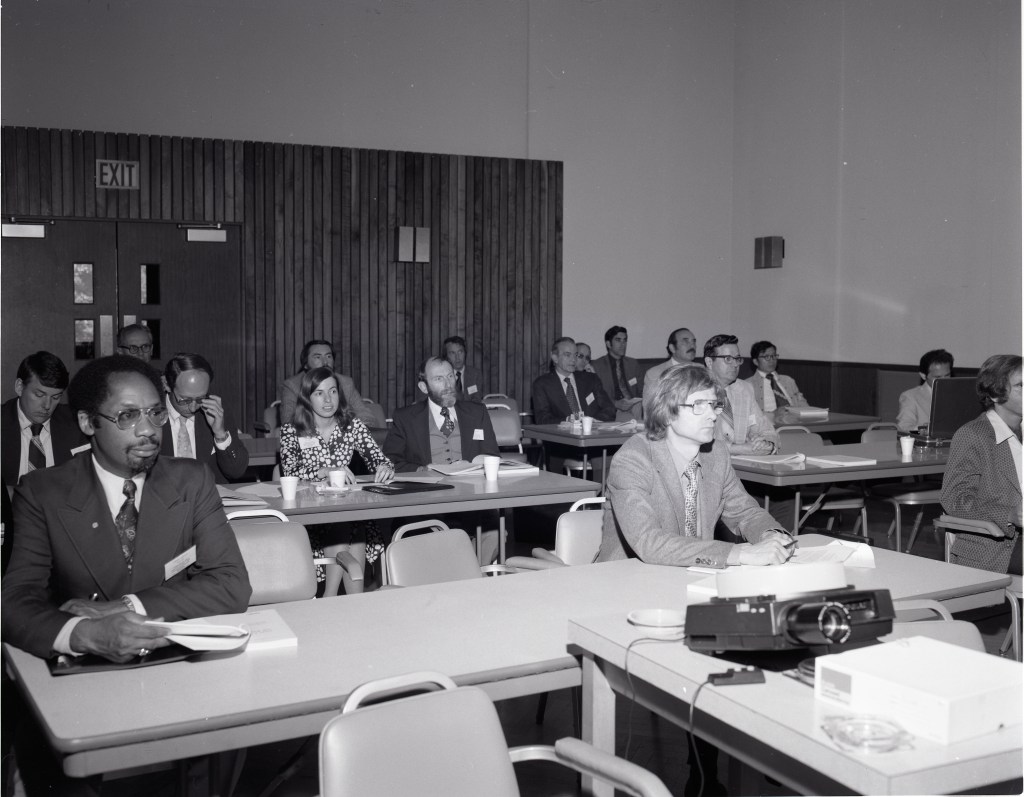 People sitting at tables and listening to a presentation.
