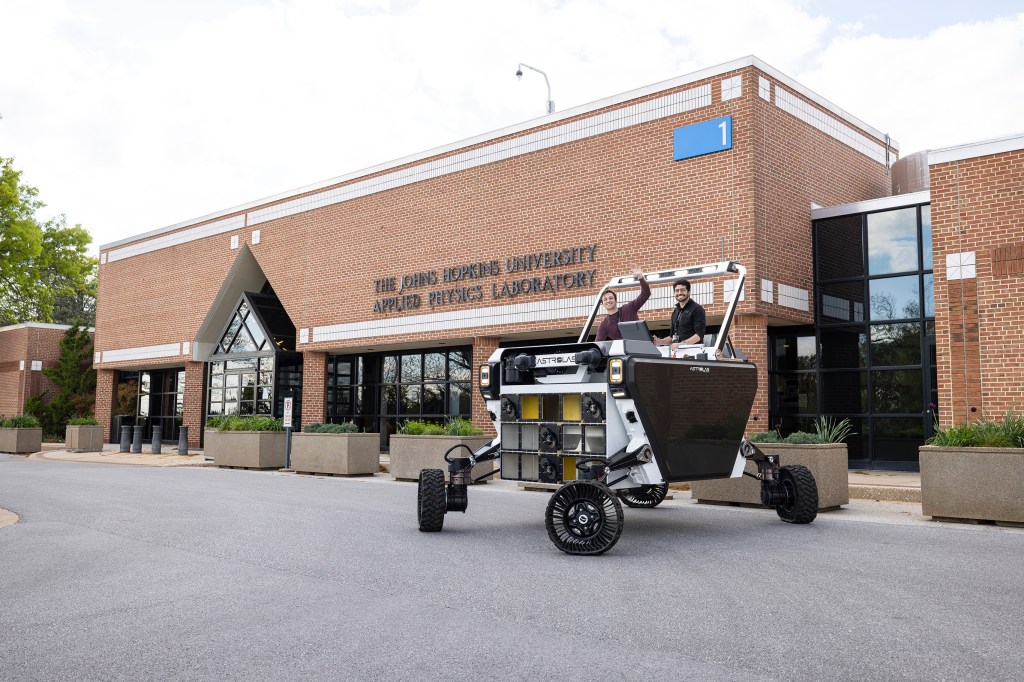 Two engineers sit in a lunar rover outside Johns Hopkins University Applied Physics Laboratory building in Maryland.