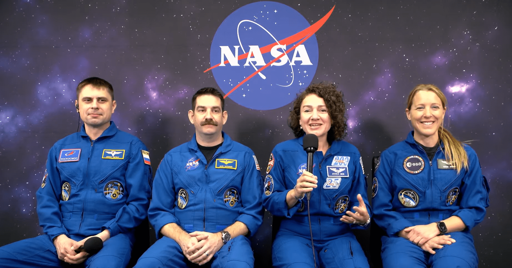 Image shows a NASA insignia in the background while four astronauts in blue flight suits sit and speak virtually to the media inside Astronaut Crew Quarters at NASA's Kennedy Space Center in Florida on Sunday, Feb. 8, 2026. Photo credit: NASA