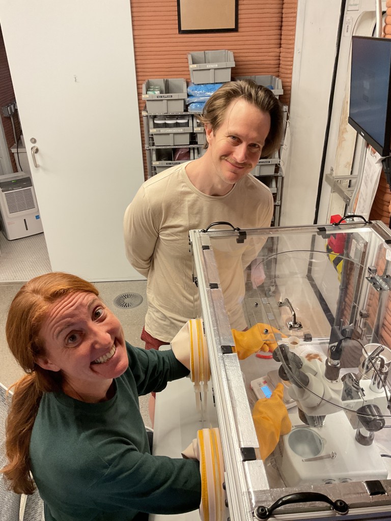 Crew Health and Performance Exploration Analog (CHAPEA) Mission 2 crew members use the glove box inside the habitat. (From left: Ellen Ellis, Matthew Montgomery)