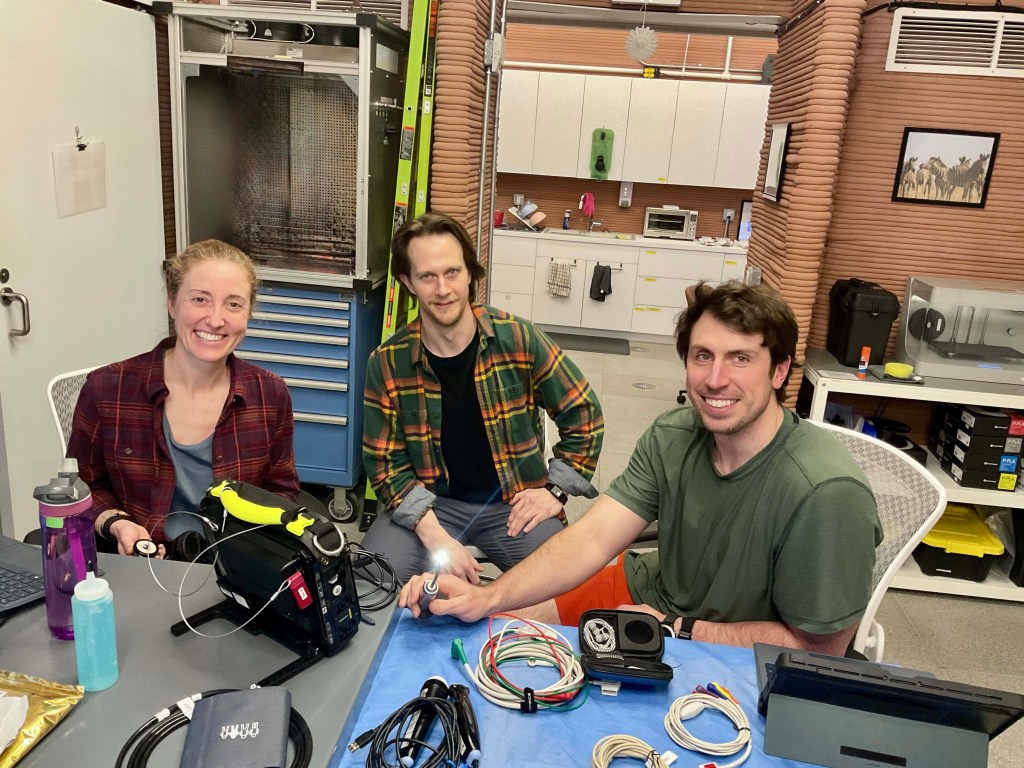 The Crew Health and Performance Exploration Analog (CHAPEA) Mission 2 crew working on improving procedures for various medical scenarios using a new medical monitoring device. (from left: Ellen Ellis, Matthew Montgomery, Ross Elder).