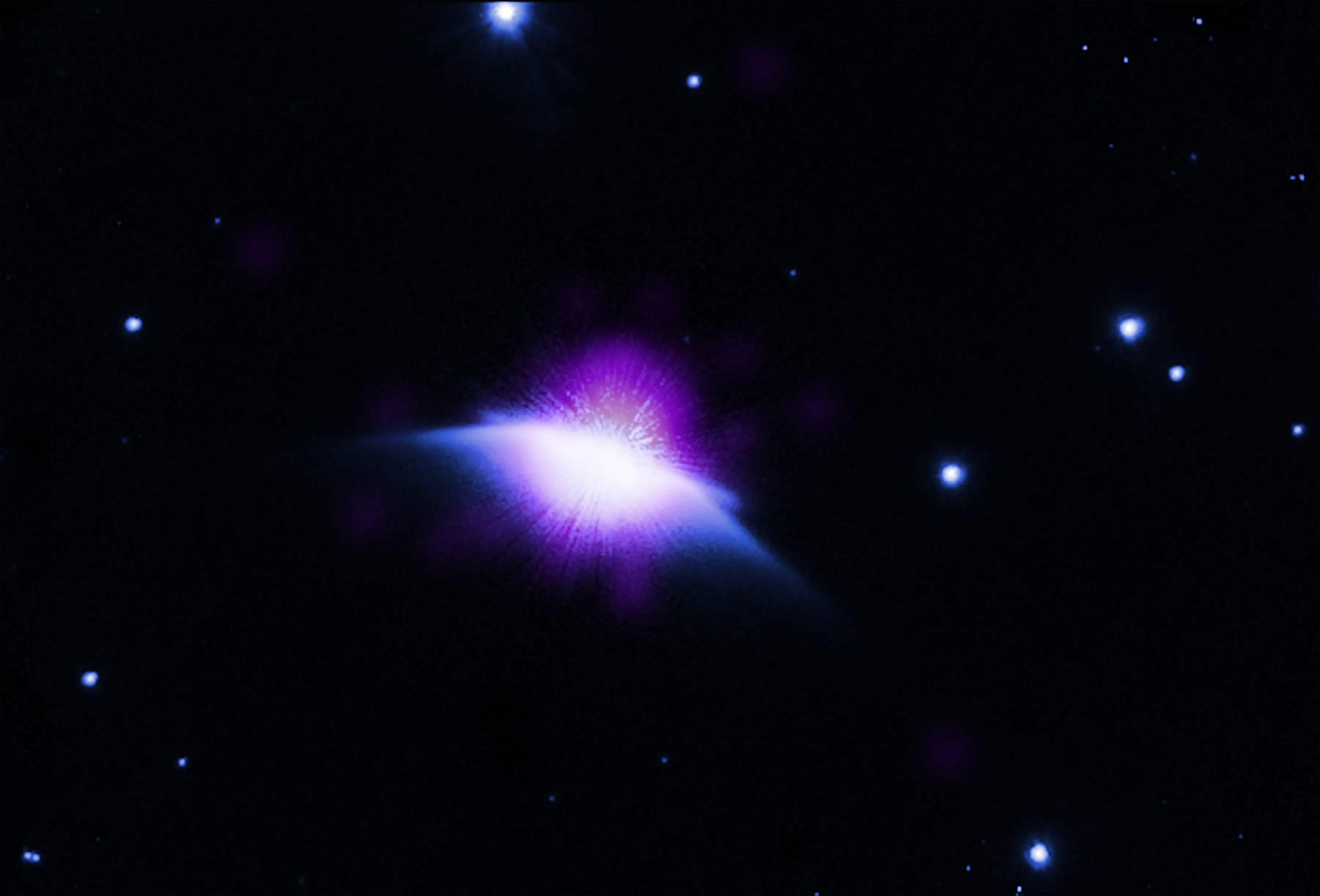 A star seen in infrared and X-ray light. There is a hazy purple bubble that reaches upward and below that, dust wings that look like a moth’s wings.