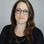 Vanessa Aubuchon's portrait image. She has dark hair, blue eyes and is wearing glasses.