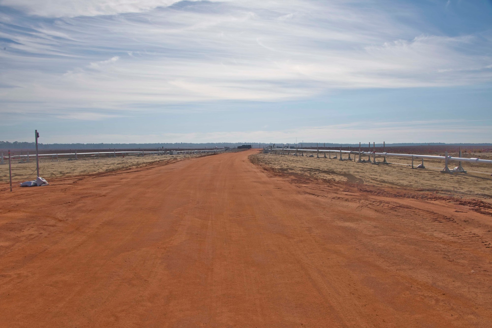 Cryogenic transfer lines on both sides of a road leading to the test article area at Eglin Air Force Base.