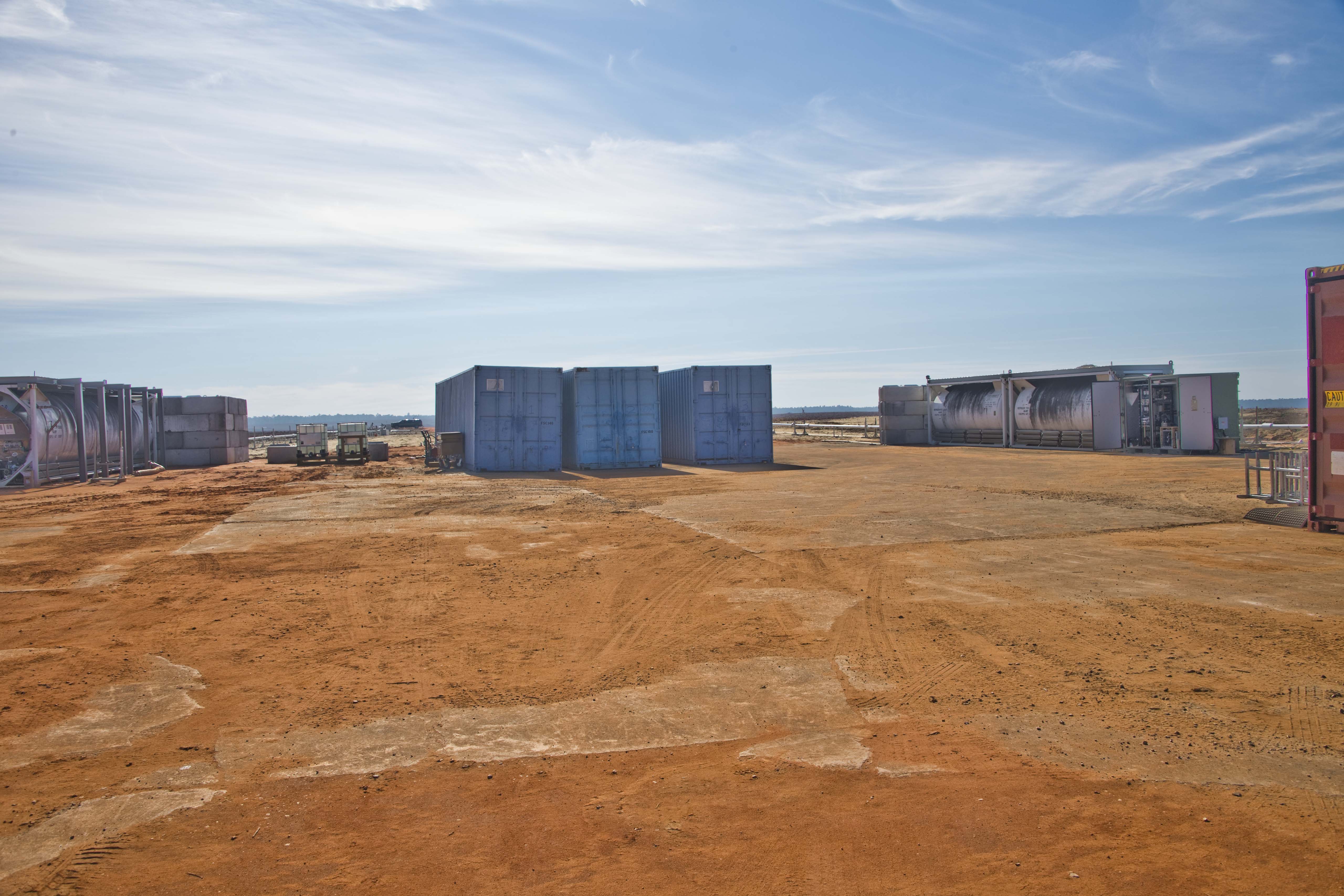 Cryogenic storage tanks and shipping containers arranged at the test site for baseline testing.