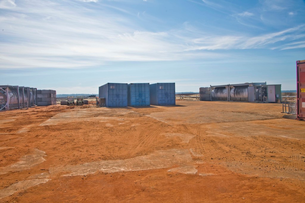 Cryogenic storage tanks and shipping containers arranged at the test site for baseline testing.