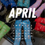 A group of people wearing different colorful socks posed in a circle with their feet all facing the center. They are floating in the picture because they are on the International Space Station on orbit.