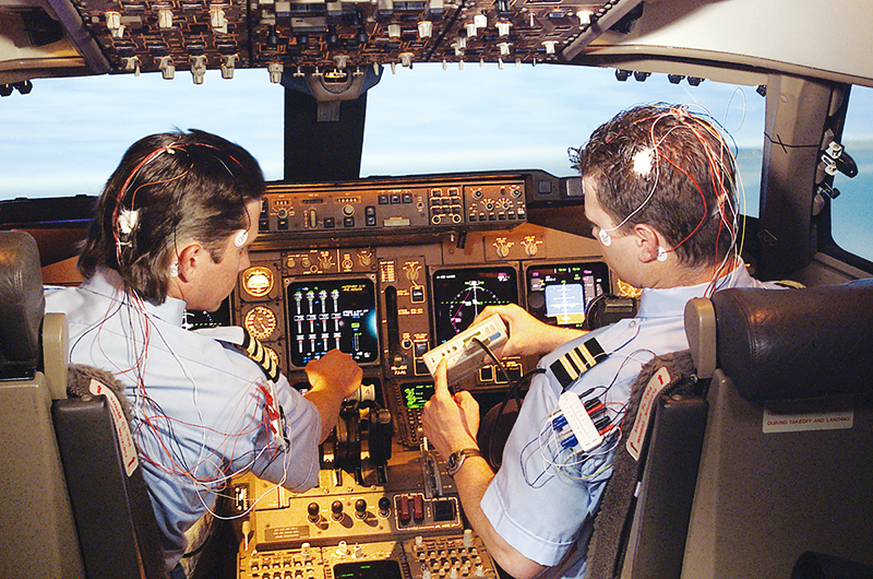 Two pilots wearing sensors to monitor fatigue.