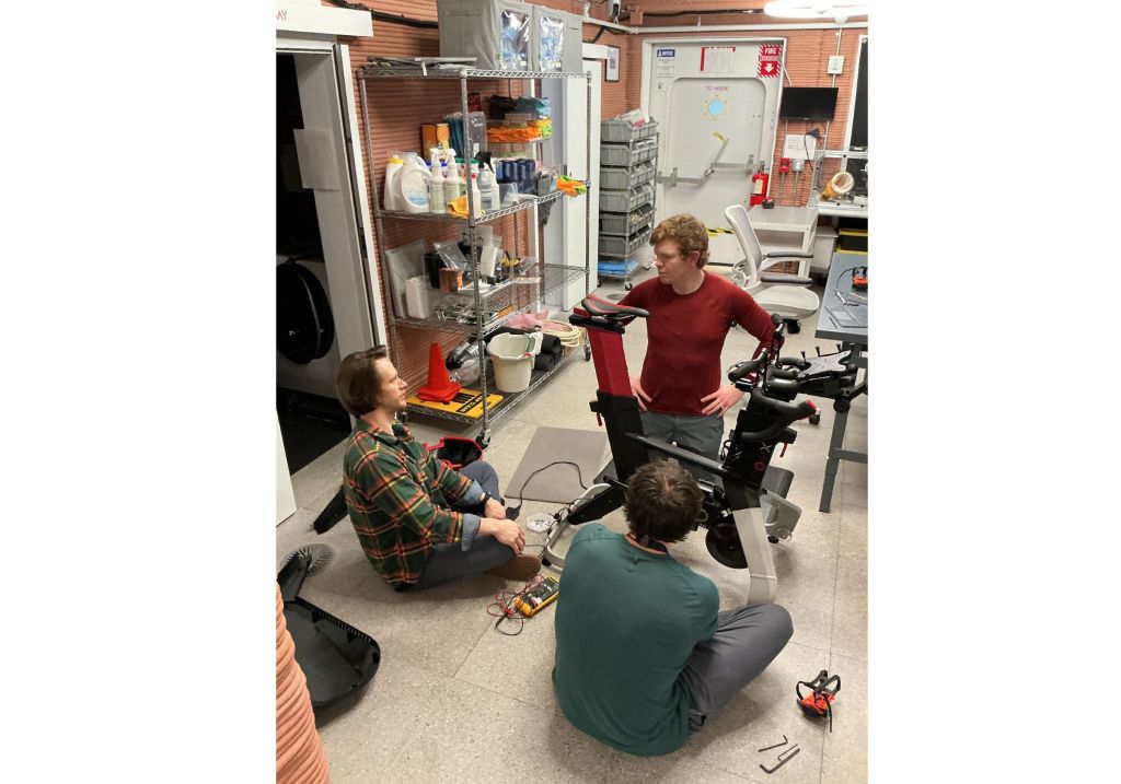 CHAPEA mission 2 crew members perform a maintenance task on their stationary bike (clockwise from the left: Matthew Montgomery, James Spicer, Ross Elder).