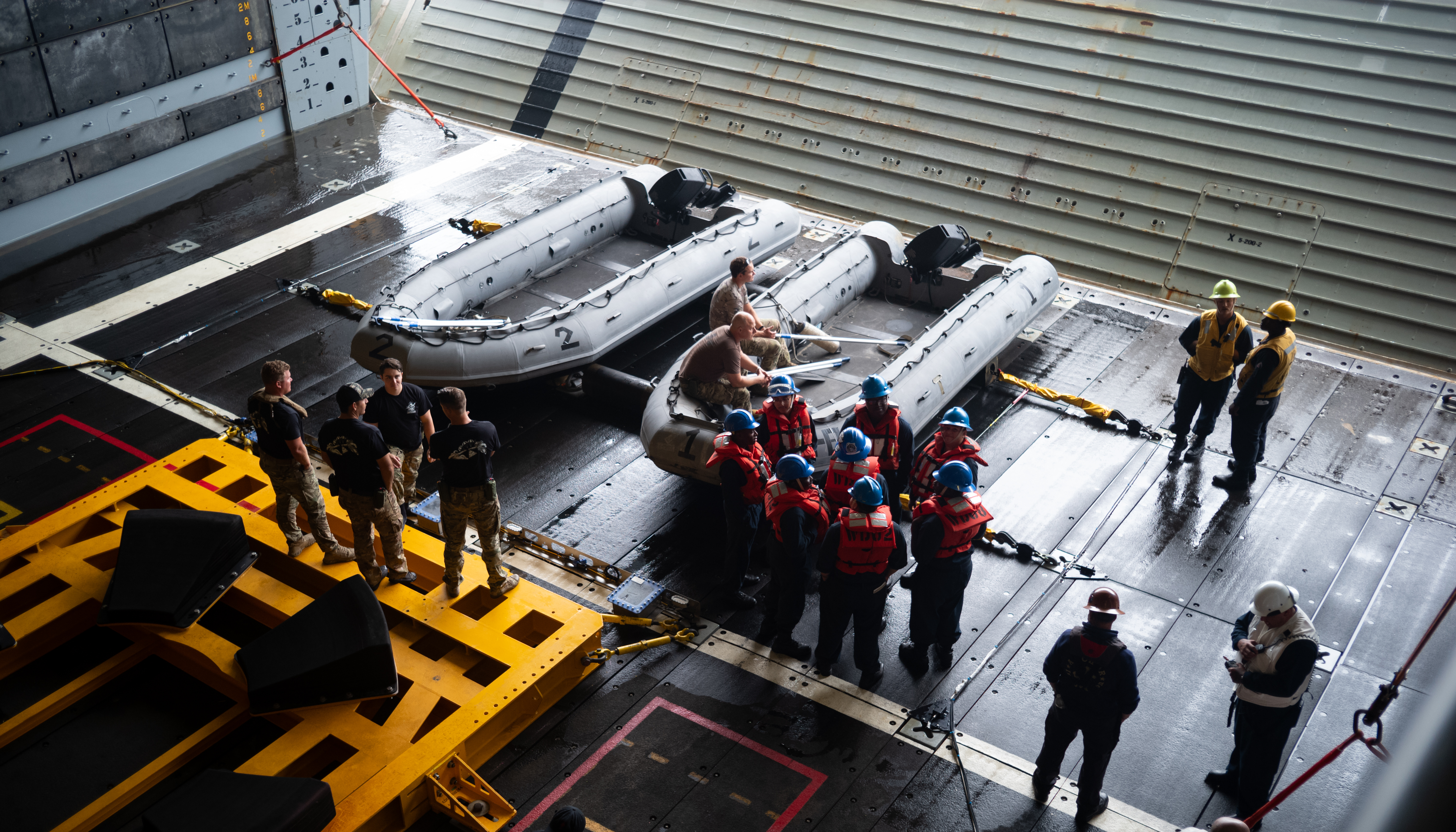 U.S. Navy personnel are seen in the well deck of USS John P. Murtha as they prepare equipment for the...