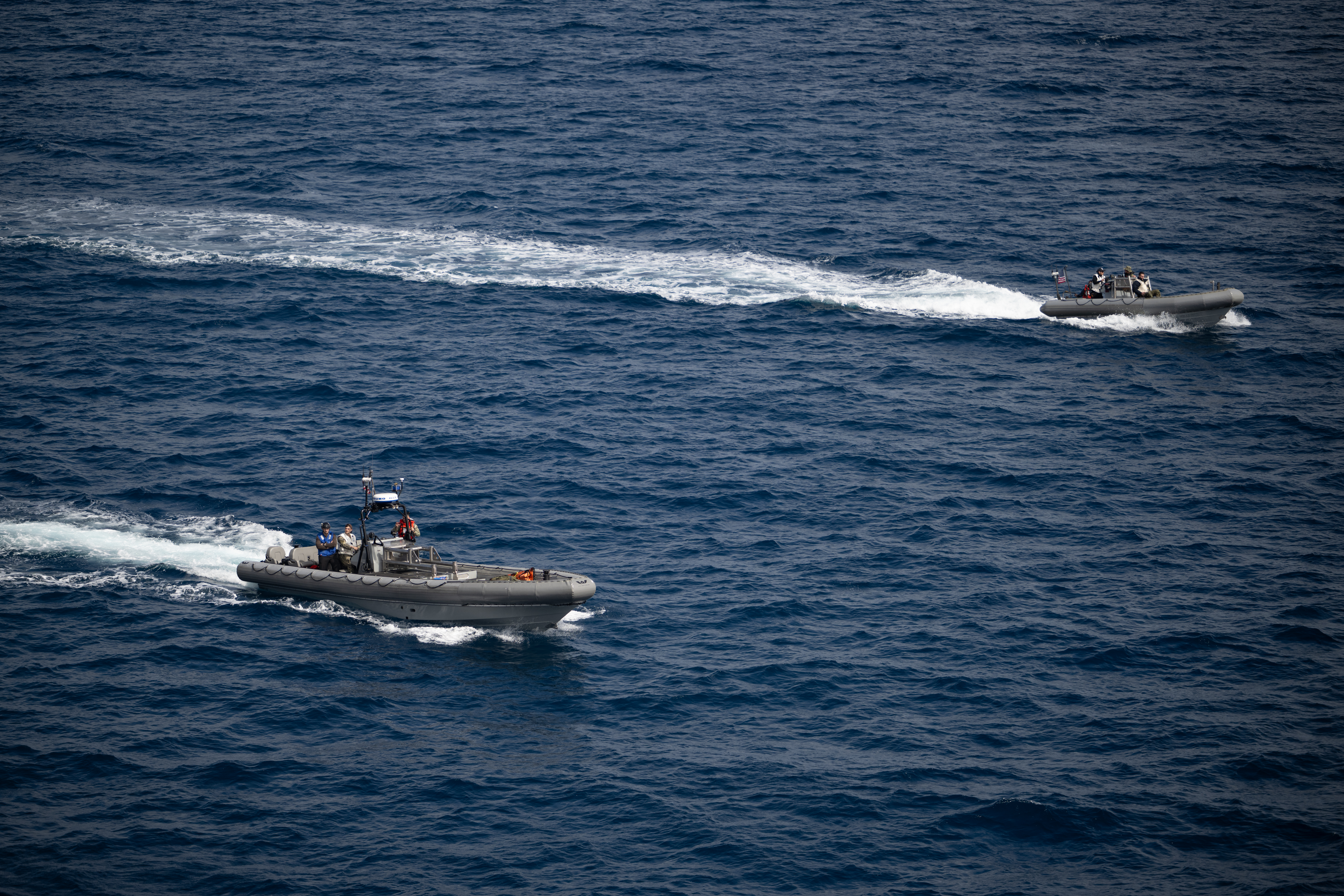 Small boats are seen alongside USS John P. Murtha as teams prepare to recover mission crewmembers crew and NASA’s Orion...