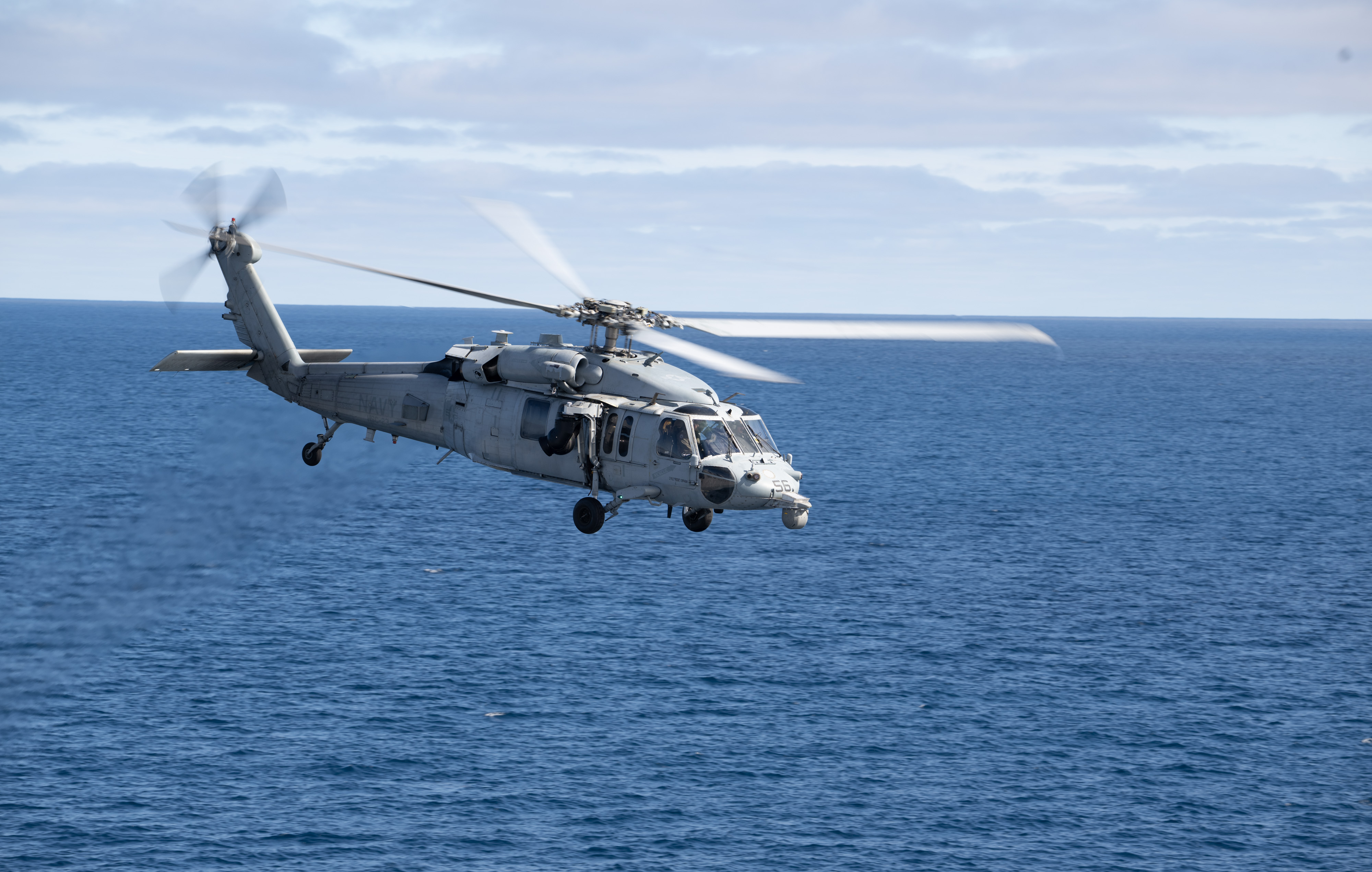 A U.S. Navy MH-60 Seahawk from Helicopter Sea Combat Squadron (HSC) 23 departs from the flight deck of USS John...
