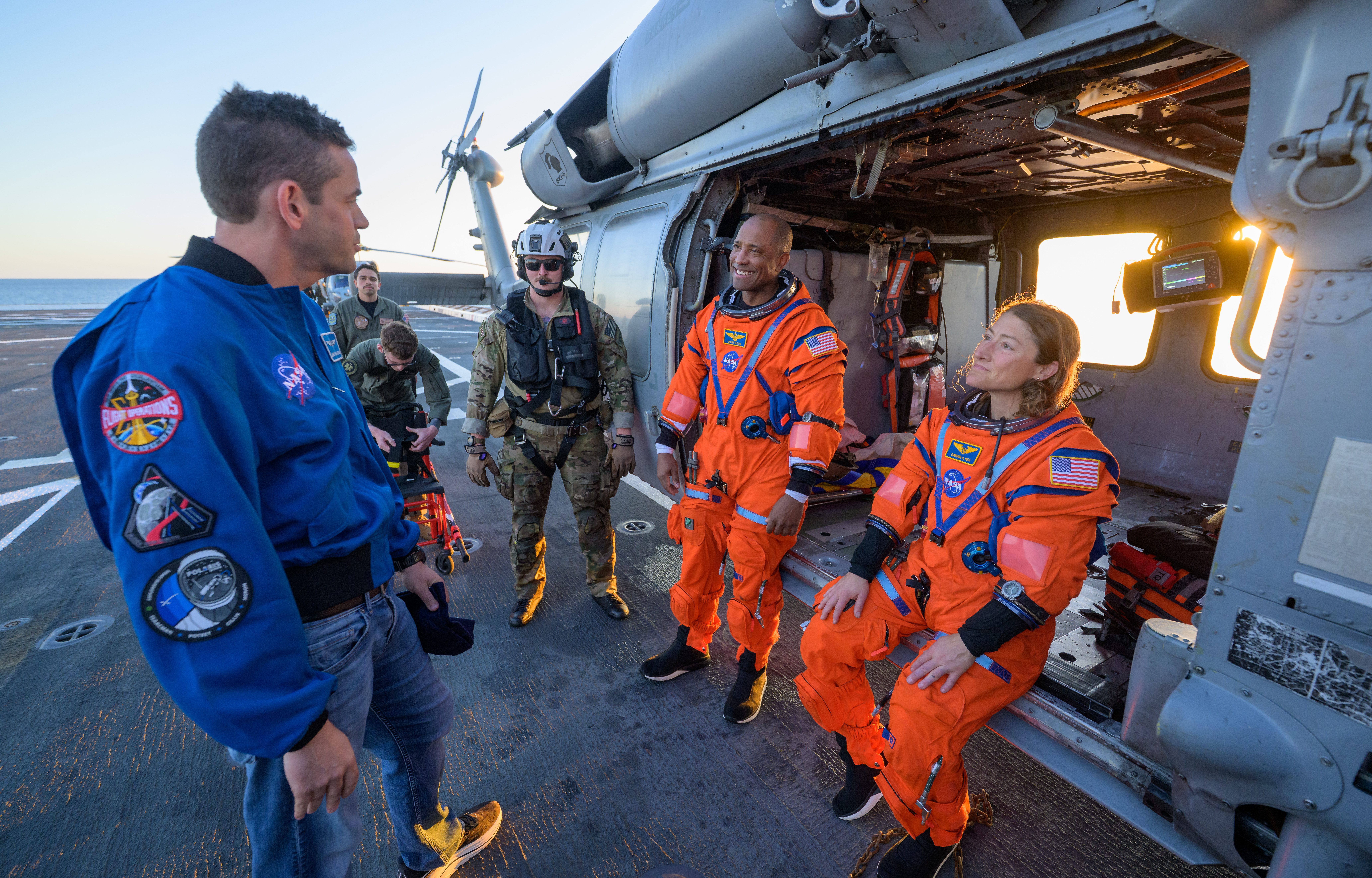 NASA astronaut Victor Glover, Artemis II pilot, left, and NASA astronaut Christina Koch, Artemis II mission specialist, talk with NASA...