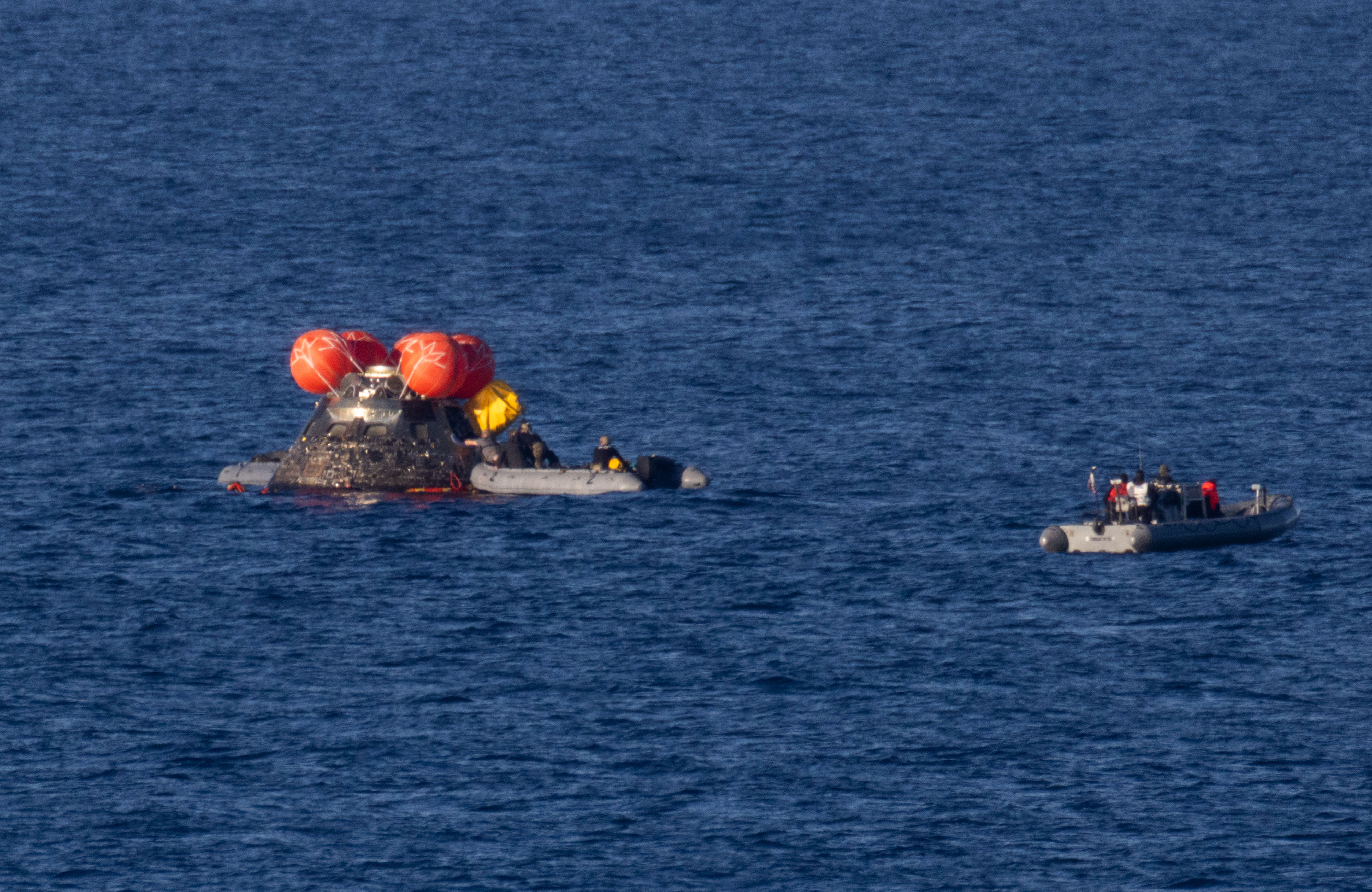 NASA’s Orion spacecraft is seen as recovery teams work to secure the spacecraft ahead of transferring Artemis II crewmembers NASA...