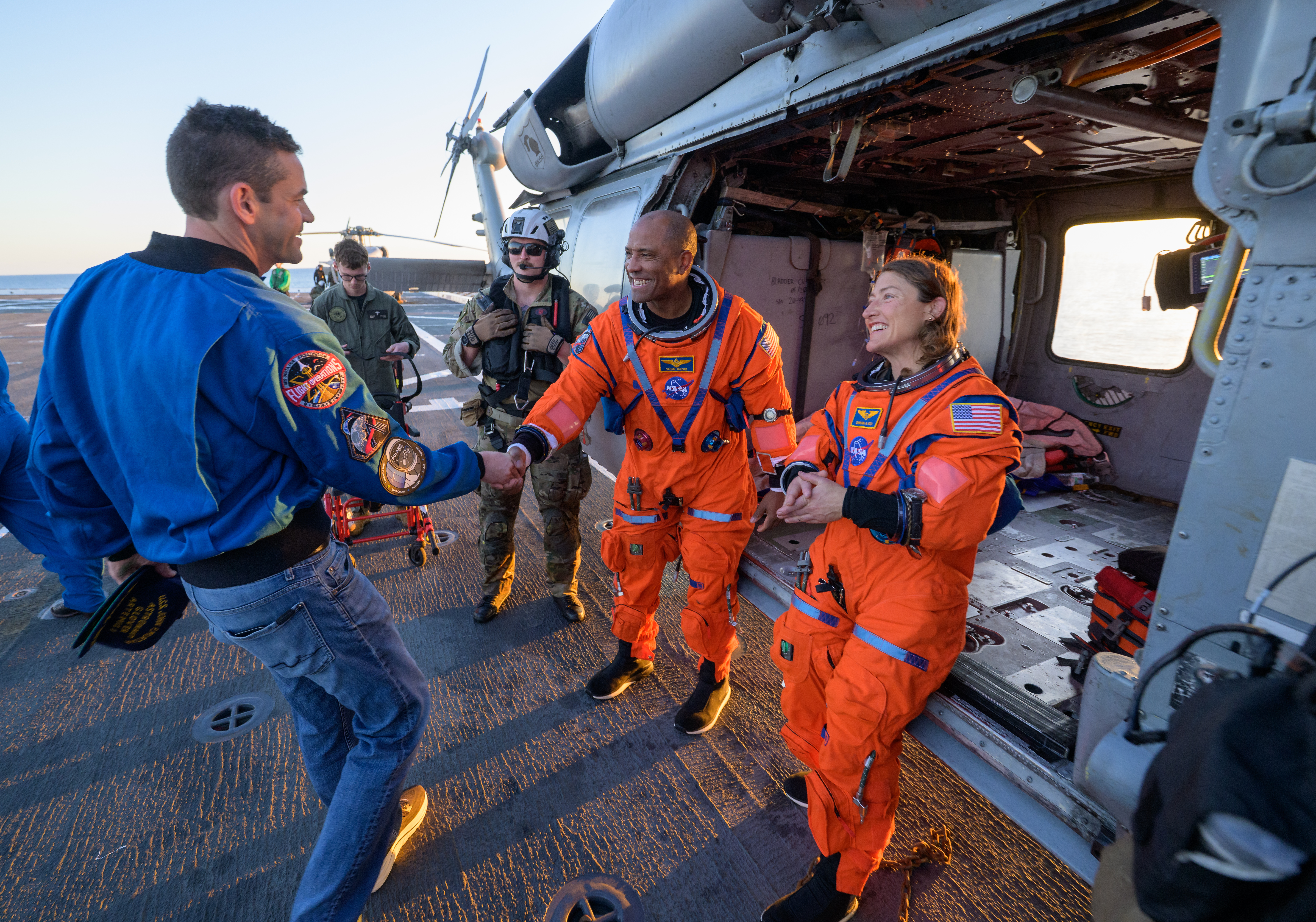 NASA astronaut Victor Glover, Artemis II pilot, left, and NASA astronaut Christina Koch, Artemis II mission specialist, talk with NASA...