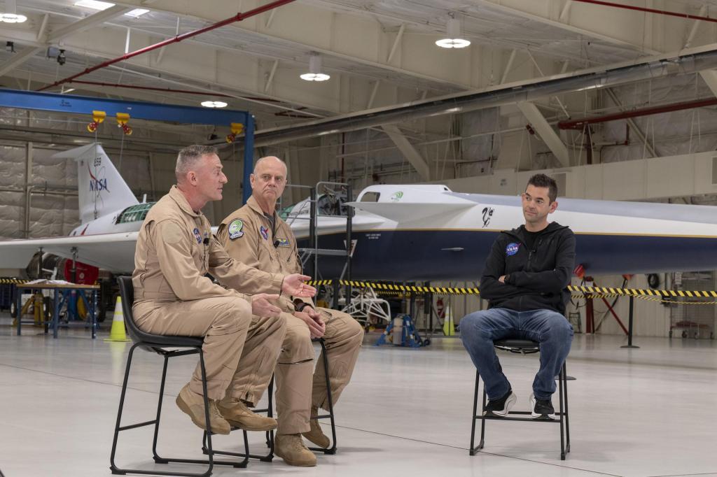 NASA Administrator Jared Isaacman, right speaks with pilots Jim "Clue" Less and Nils Larson.