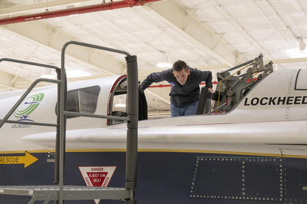 NASA Administrator Jared Isaacman looking into the cockpit of the X-59 aircraft.