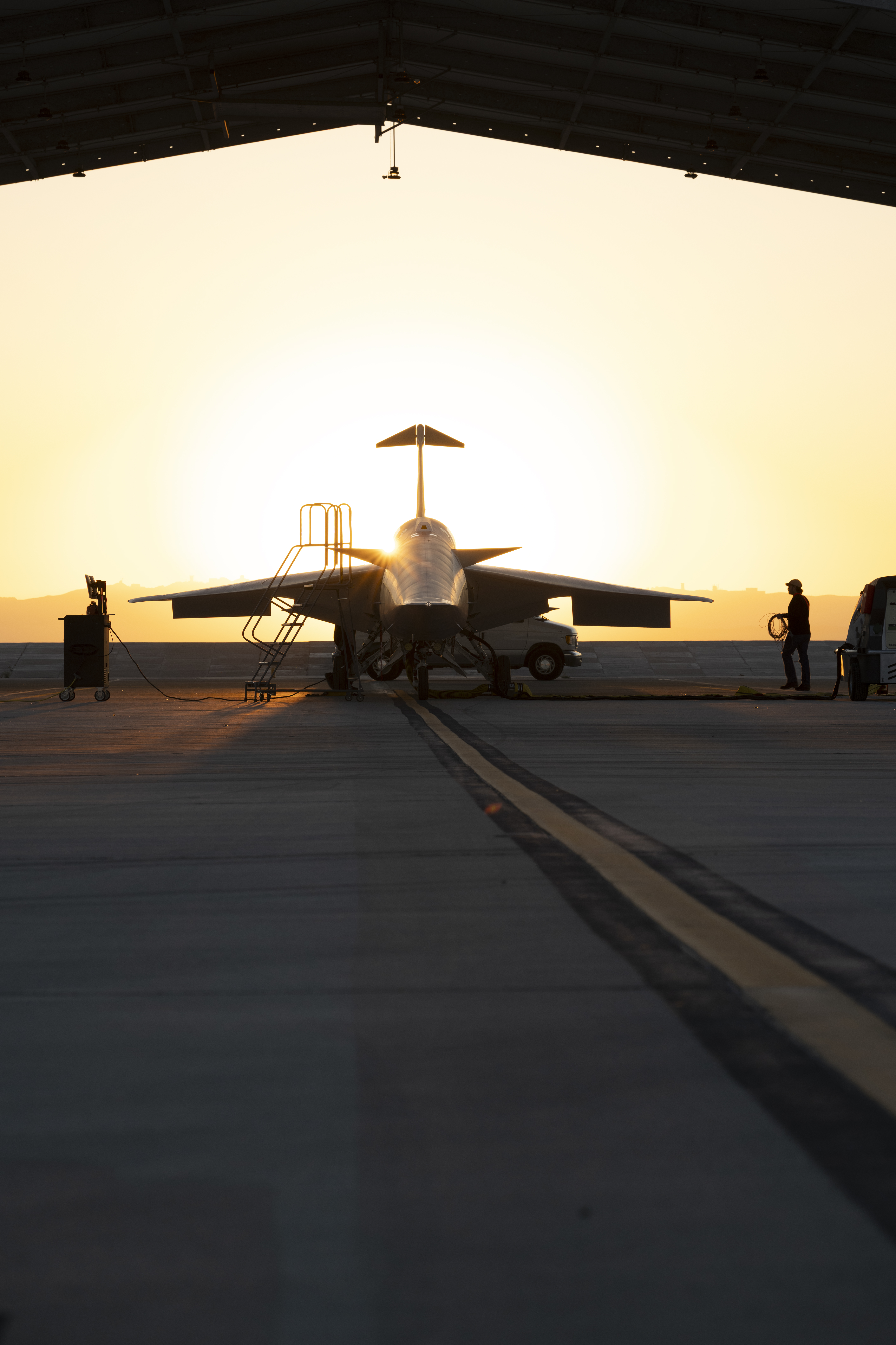Face front view of NASA’s X-59 quiet supersonic research aircraft sitting in a run stall during sunrise.