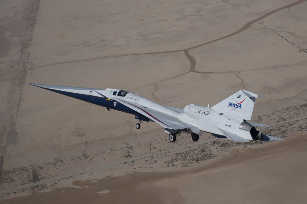 X-59 in flight with it's landing gears down on the aircraft.