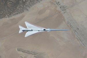 Aerial view looking down onto the X-59 while it's in flight over the Mojave Desert.