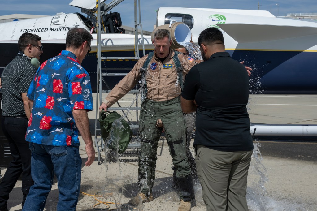 NASA's X-59 Test Pilot being drenched with water after completing his first flight.