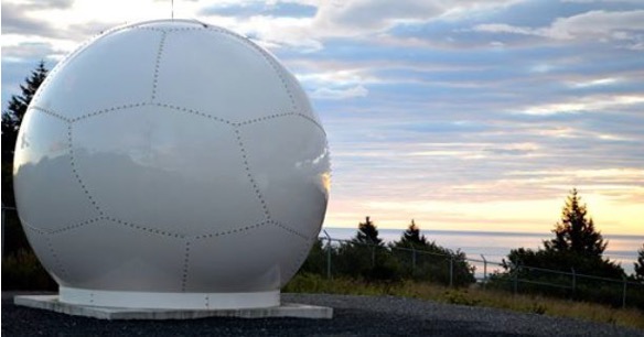A large white sphere with dotted lines on it, in an outdoor setting