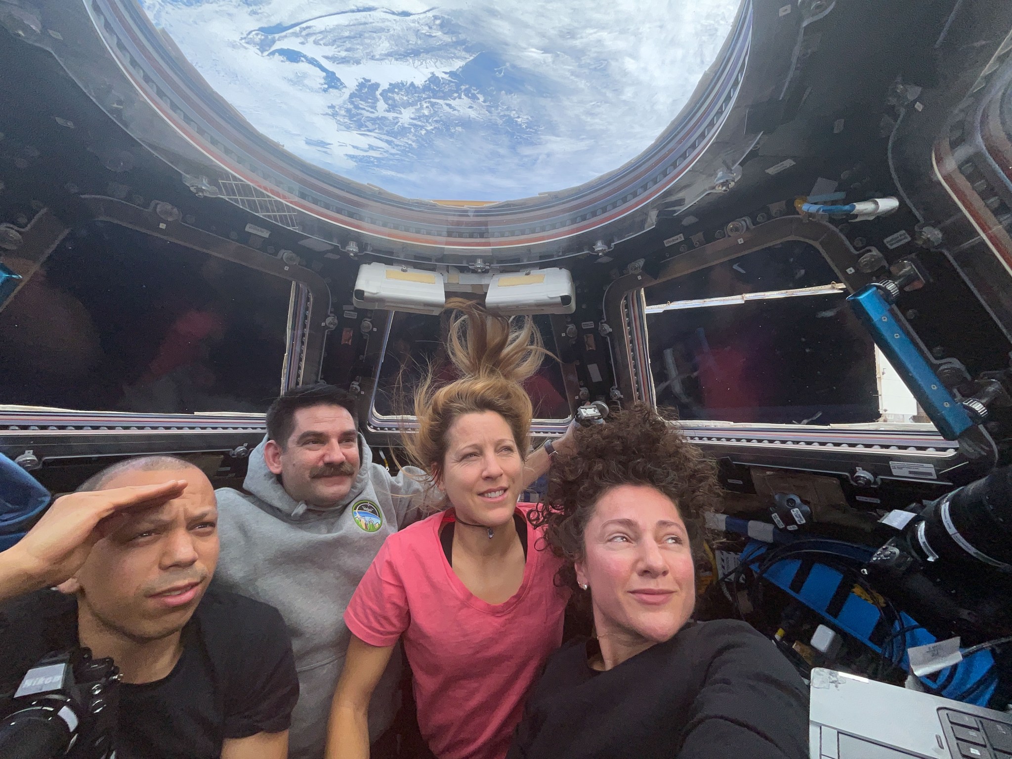 Expedition 74 flight engineers (from left) Chris Williams, Jack Hathaway, Sophie Adenot, and Jessica Meir are inside the International Space Station’s cupola, waiting to observe the plasma trail of the Orion spacecraft—with the Artemis II crew aboard—as it reenters Earth’s atmosphere.