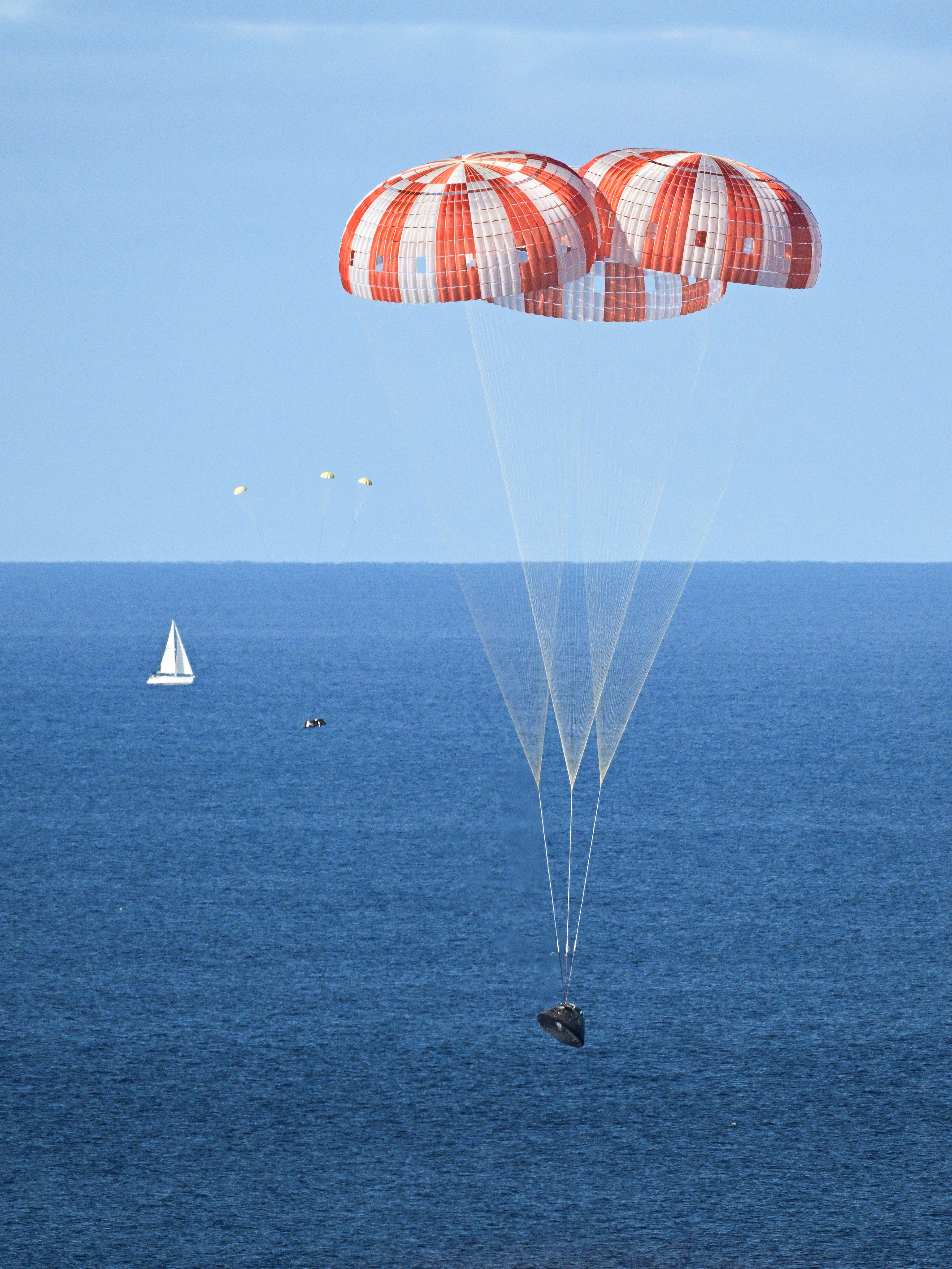 PHOTO DATE: April 10, 2026.LOCATION: Off the coast of California. SUBJECT: NASA’s Orion capsule descends under its main parachutes over...