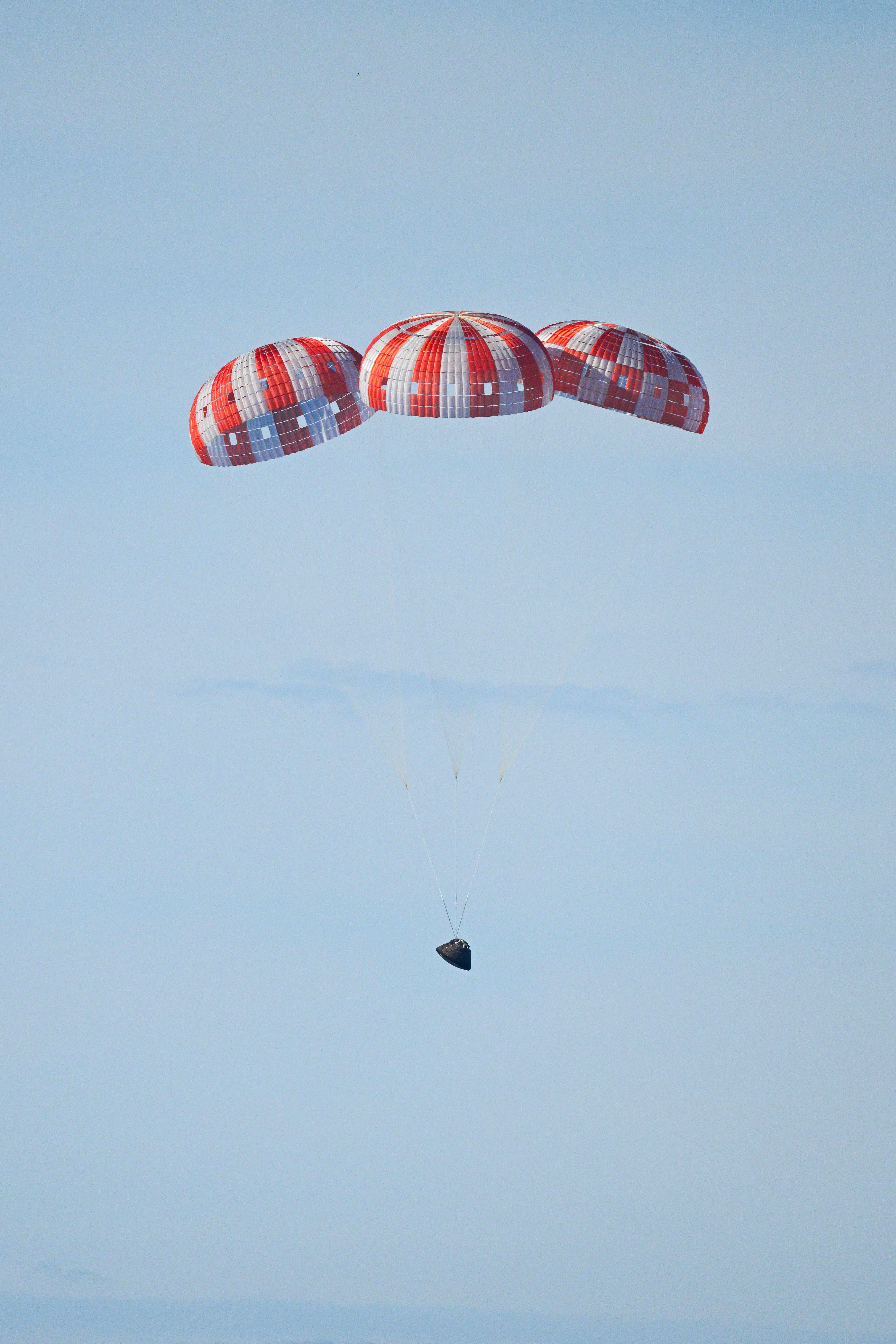 Parachutes secured to NASA’s Orion spacecraft deploy before splashdown in the Pacific Ocean near San Diego, California, on Friday, April...