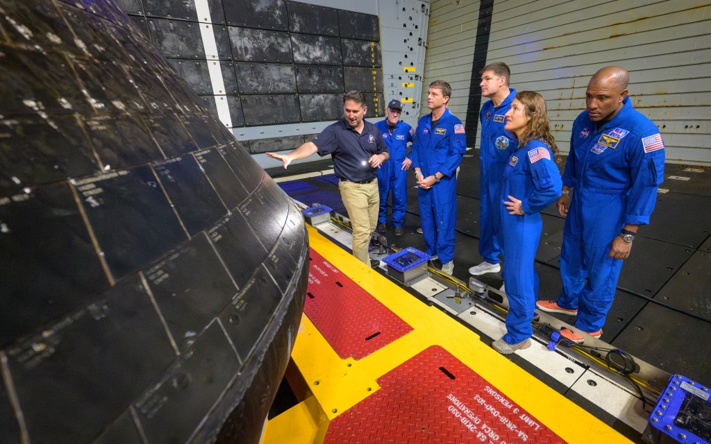 Luis Saucedo, director de la Oficina de Integración de los Vehículos de Orion, a la izquierda, inspecciona la nave espacial Orion junto con Richard Scheuring, cirujano de vuelo de la NASA, y los miembros de la tripulación de Artemis II tras el regreso de la misión, el 11 de abril de 2026.