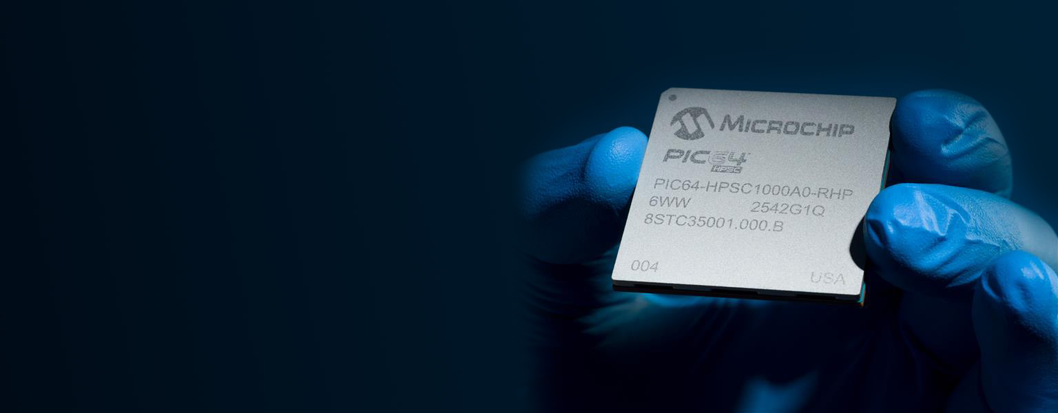 Person wearing gloves holding a microchip