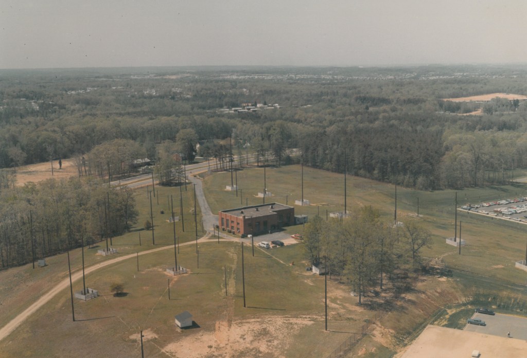 red brick building on a hill surrounded by tall antennae structures