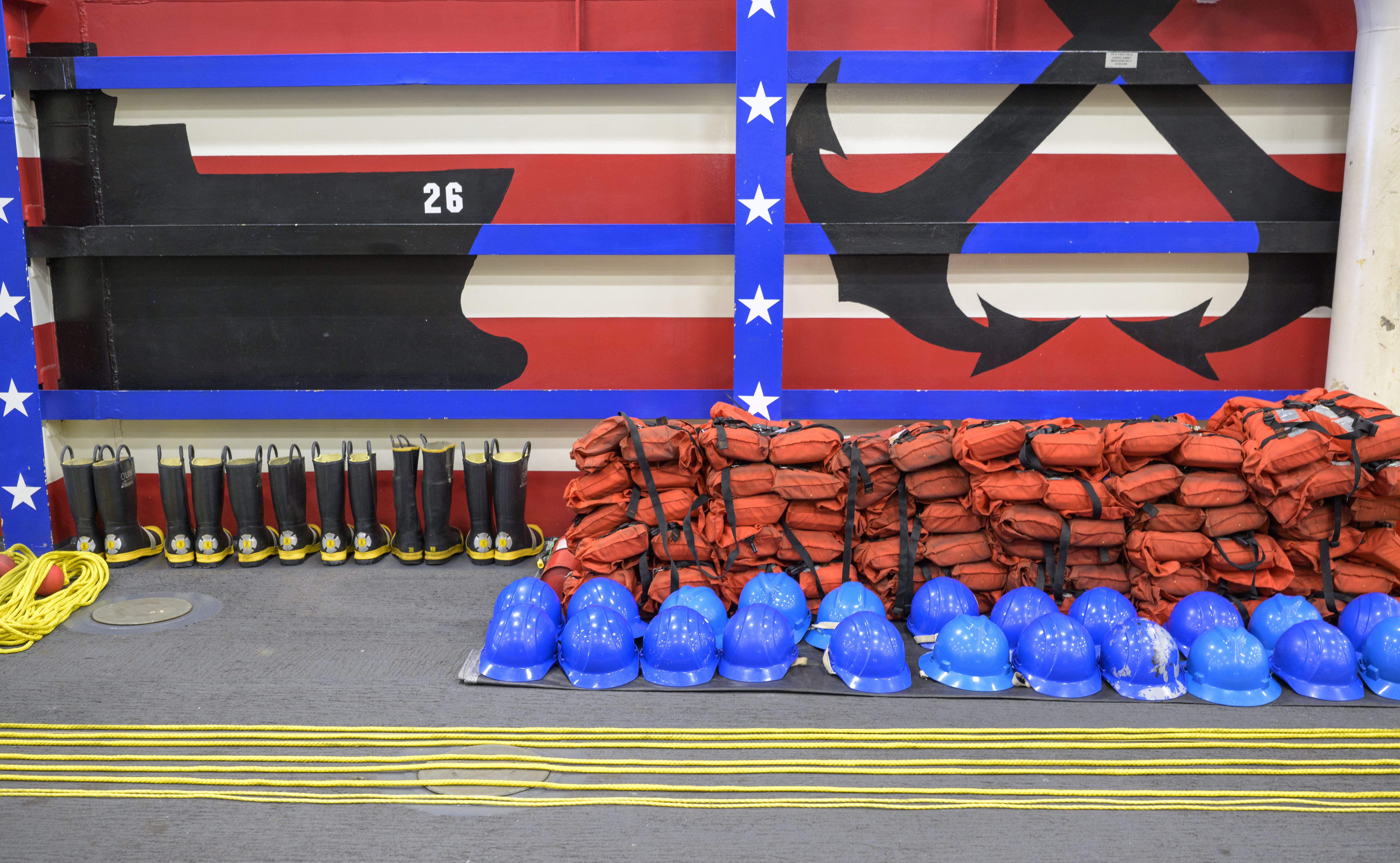 Life jackets, helmets, throw ropes, and boots are seen laid out onboard USS John P. Murtha as NASA, U.S. Navy.,...