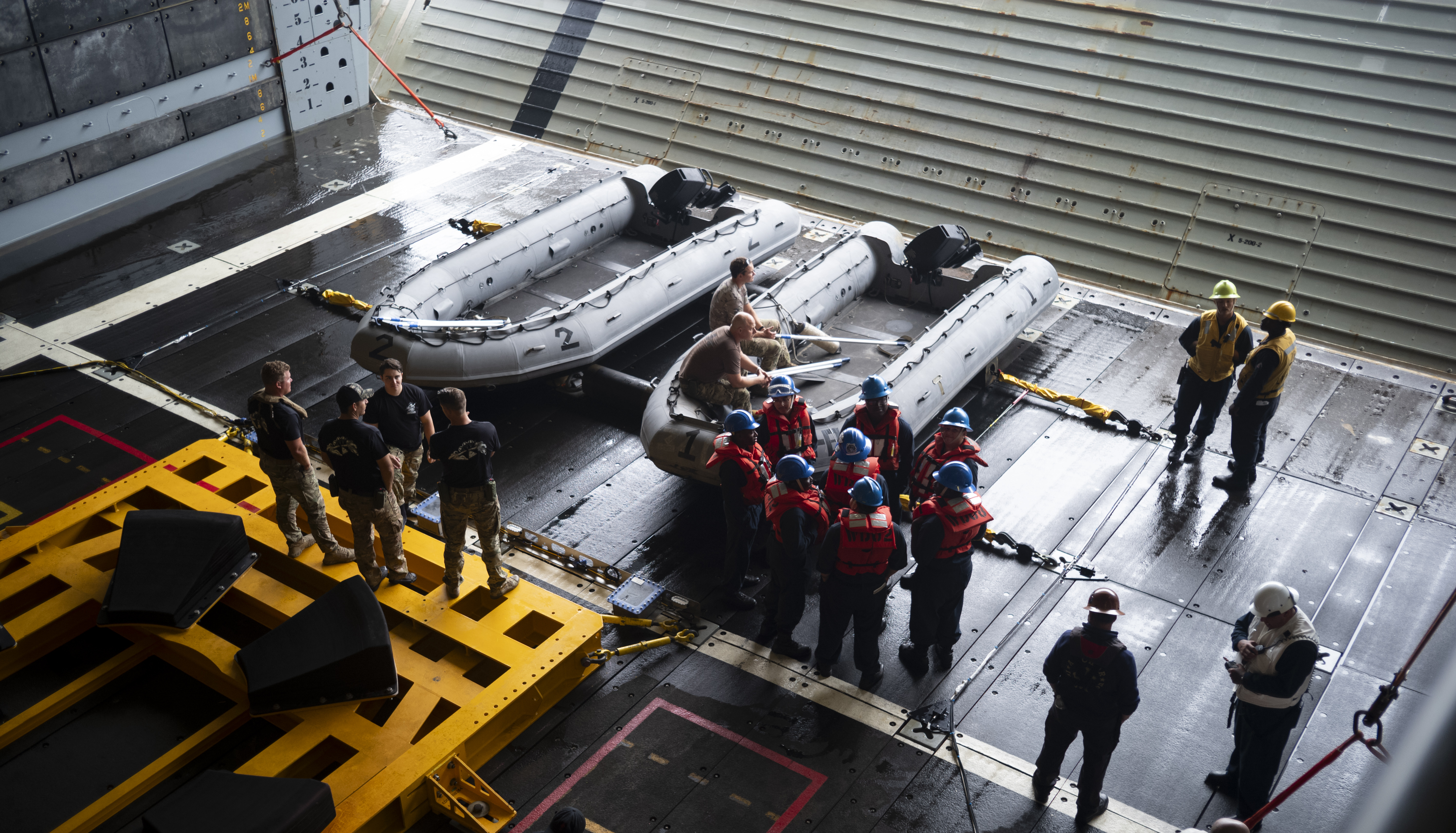 U.S. Navy personnel are seen in the well deck of USS John P. Murtha as they prepare equipment for the...