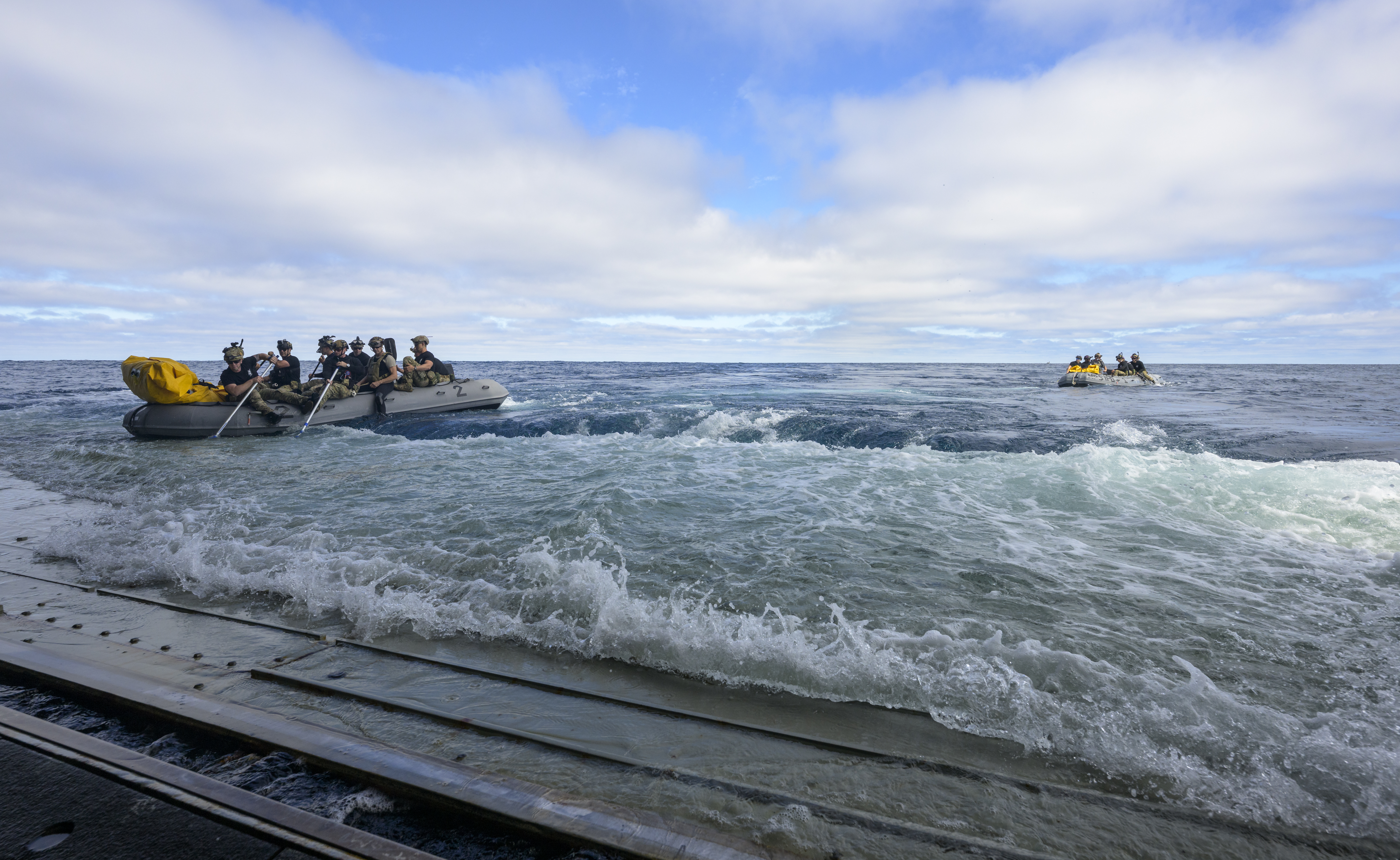 U.S. Navy divers deploy in small boats from the well deck of USS John P. Murtha to recover Artemis II...