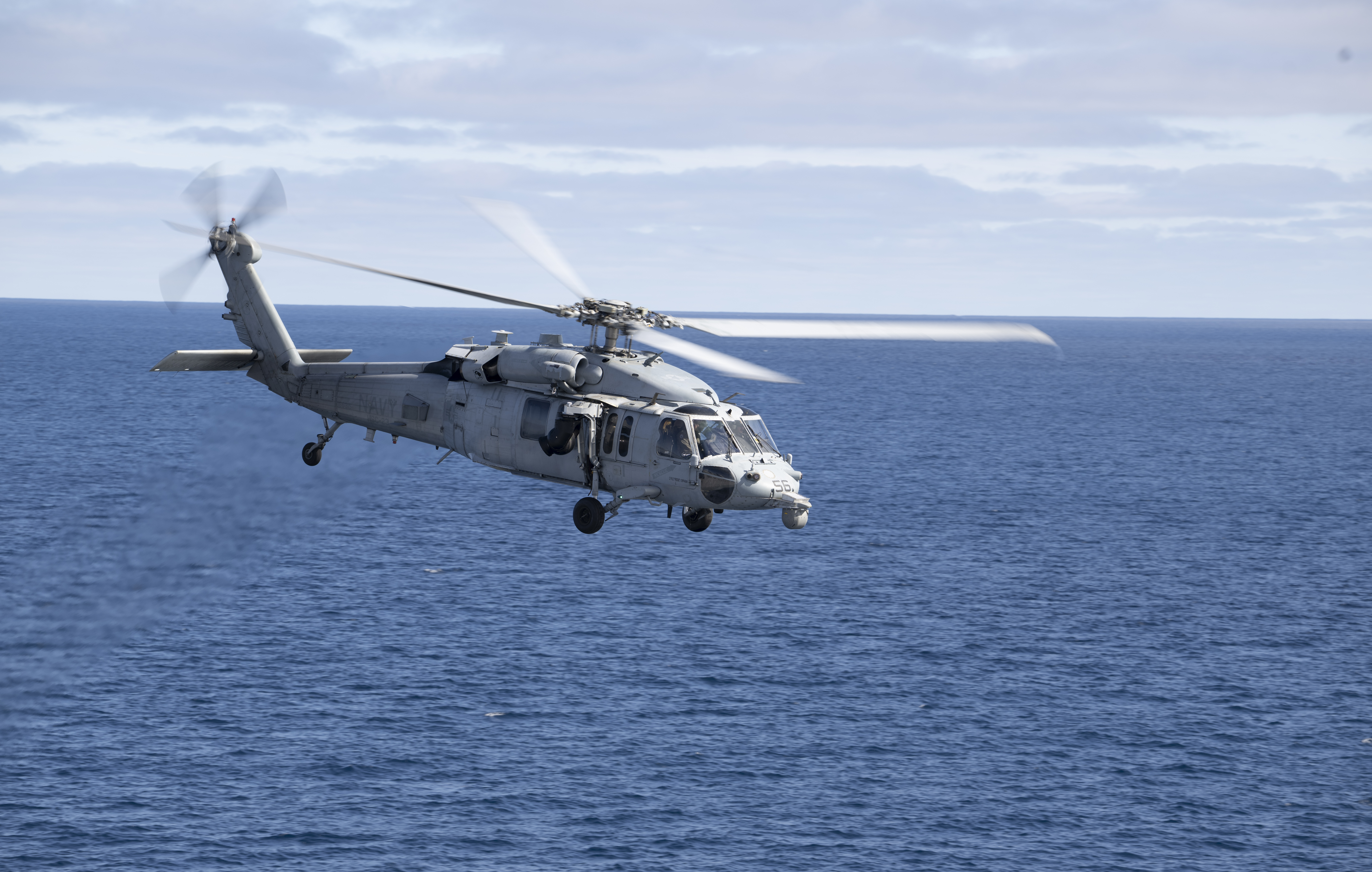 A U.S. Navy MH-60 Seahawk from Helicopter Sea Combat Squadron (HSC) 23 departs from the flight deck of USS John...