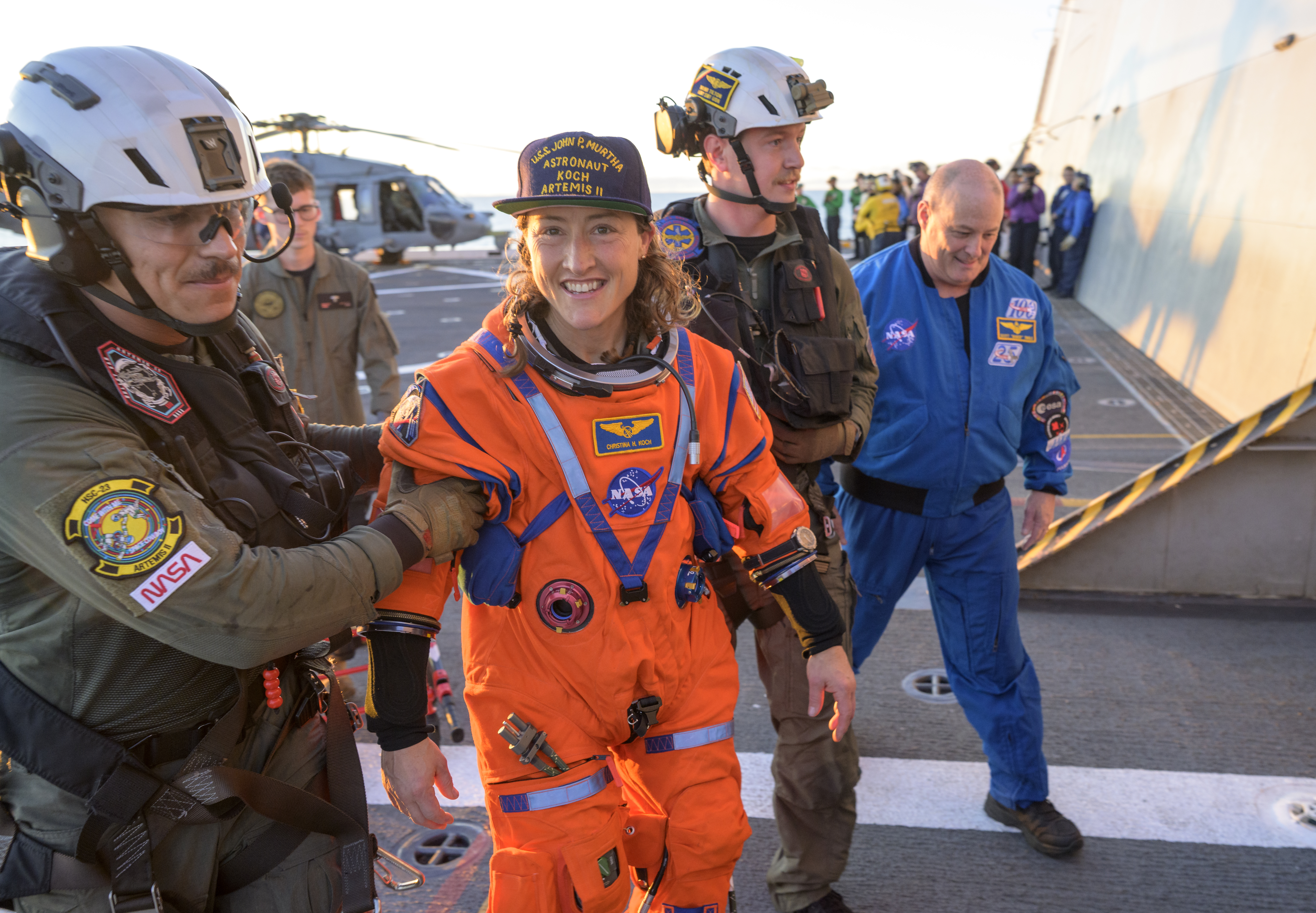 NASA astronaut Christina Koch, Artemis II mission specialist is assisted off the flight deck after arriving aboard USS John P....