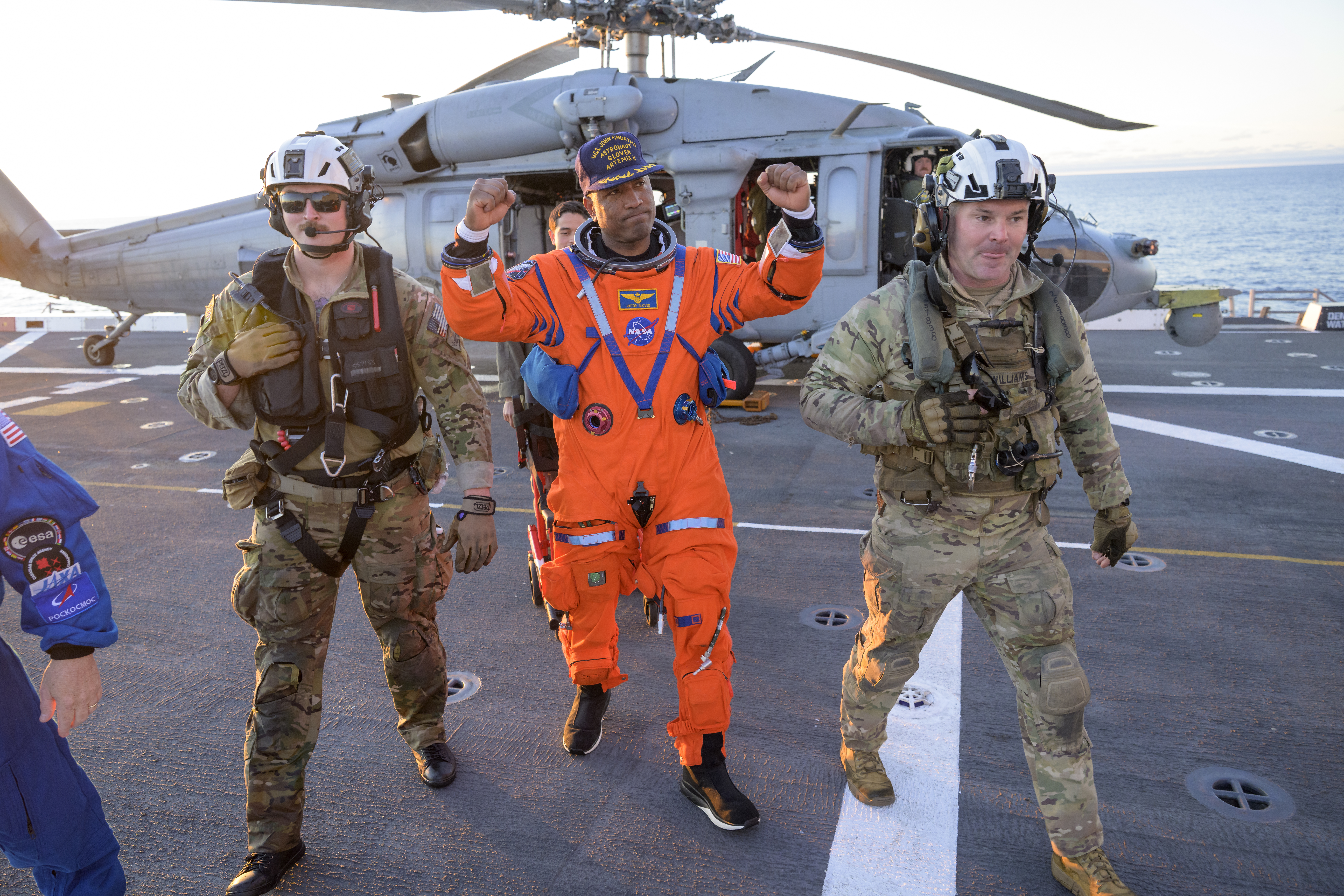 NASA astronaut Victor Glover, Artemis II pilot is assisted off the flight deck after arriving aboard USS John P. Murtha...