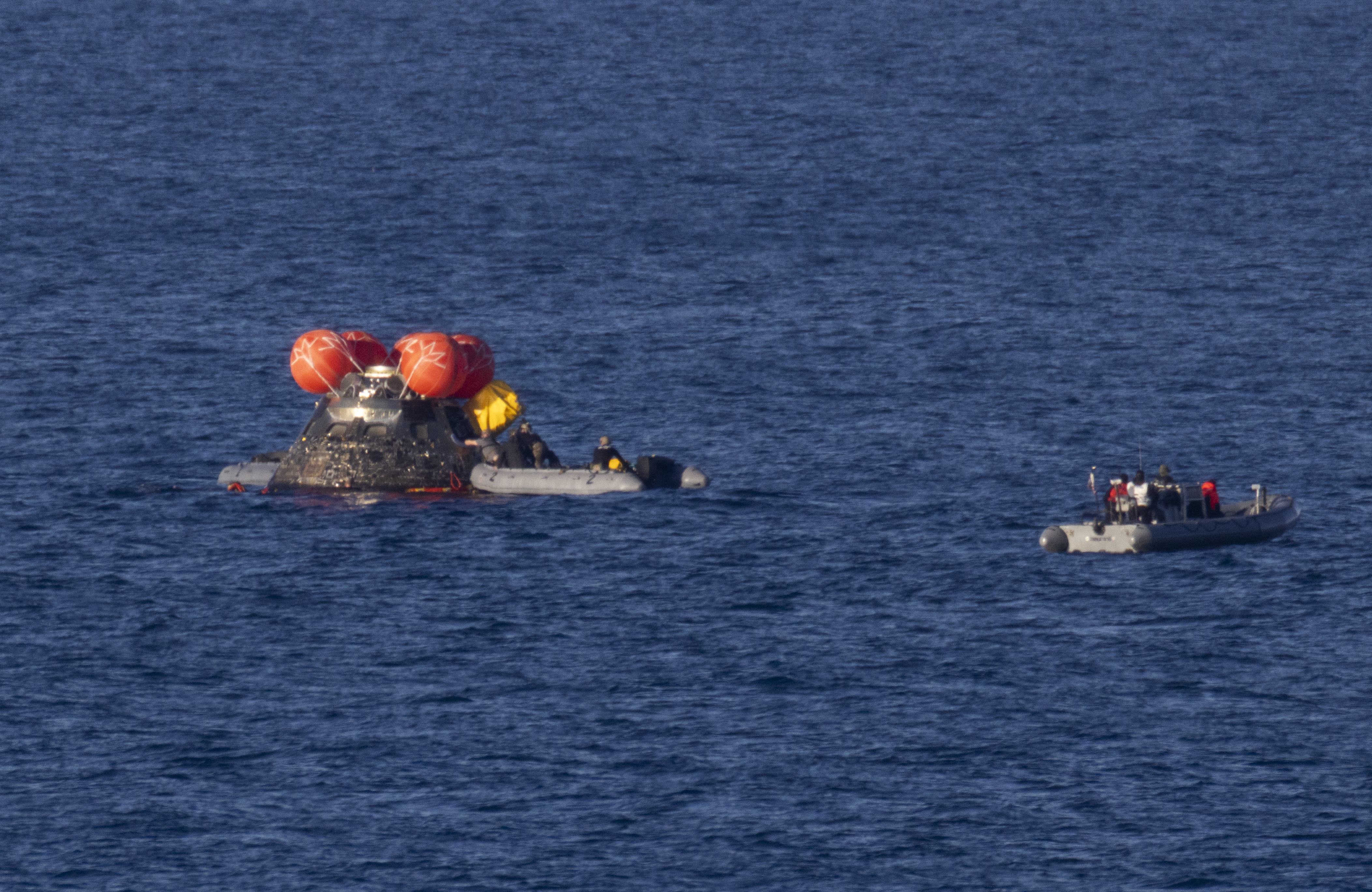 NASA’s Orion spacecraft is seen as recovery teams work to secure the spacecraft ahead of transferring Artemis II crewmembers NASA...
