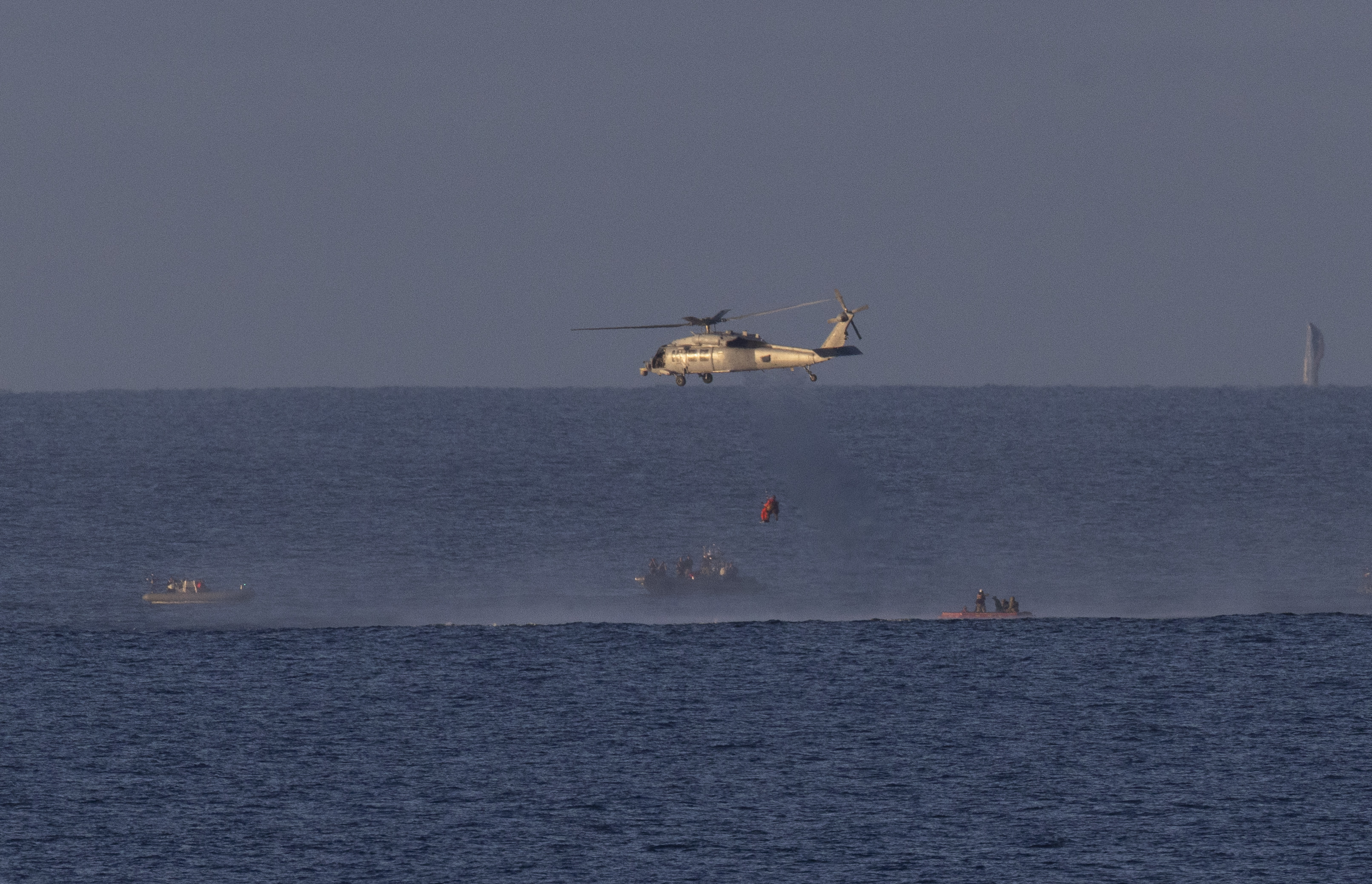 A Navy MH-60 Seahawk from Helicopter Sea Combat Squadron (HSC) 23 is seen as it lifts NASA astronaut Victor Glover,...